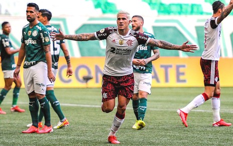 Pedro, do Flamengo, comemora gol contra o Palmeiras. Ele usa uma camisa branca e está de braços abertos