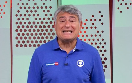 Cléber Machado usando uma uma camisa azul, com um fundo verde dos estúdios da Globo em São Paulo, durante uma transmissão