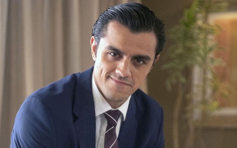 O ator Felipe Simas usa terno e gravata e está com os cabelos penteados para trás na pele de Heitor, seu personagem em Fuzuê