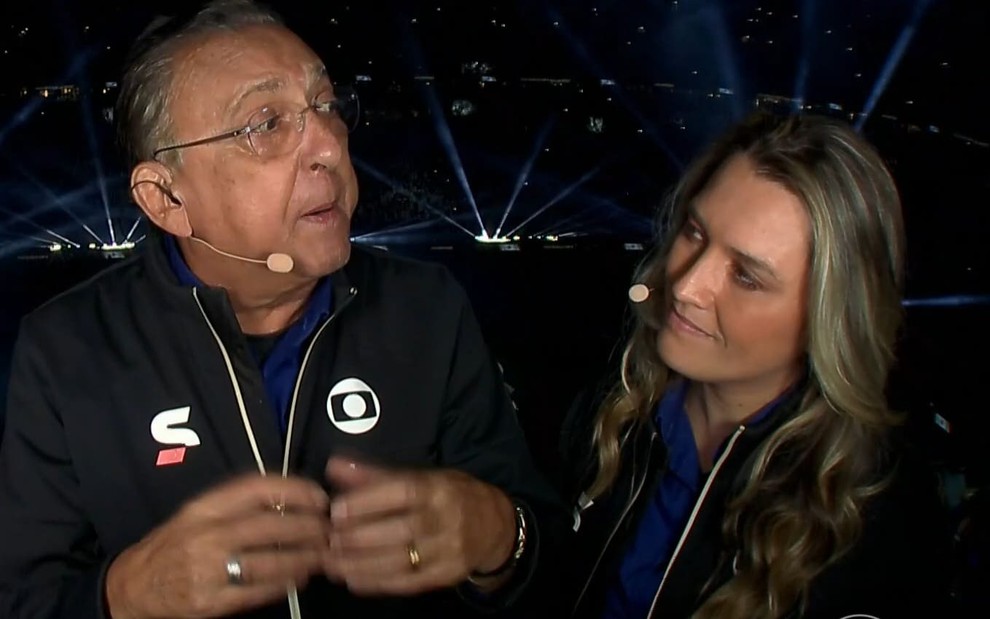 Galvão Bueno e Ana Thaís Matos usam os agasalhos pretos uniformes da transmissão da Copa; narrador encara a comentarista