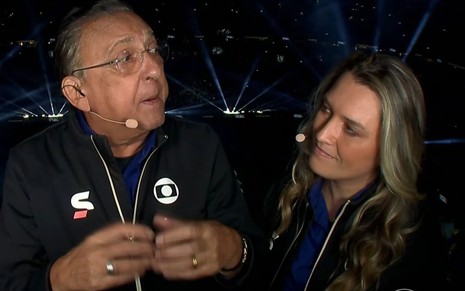 Galvão Bueno e Ana Thaís Matos usam os agasalhos pretos uniformes da transmissão da Copa; narrador encara a comentarista