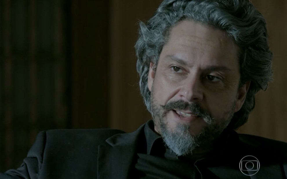 José Alfredo (Alexandre Nero)  está sentado em poltrona no quarto de Maria Marta (Lilia Cabral) em Império