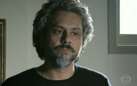 José Alfredo (Alexandre Nero) está em pé no quarto do bar do Manoel (Jackson Antunes) em cena de Império