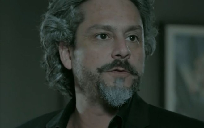 José Alfredo (Alexandre Nero) está em pé na sala da mansão dos Medeiros em cena de Império
