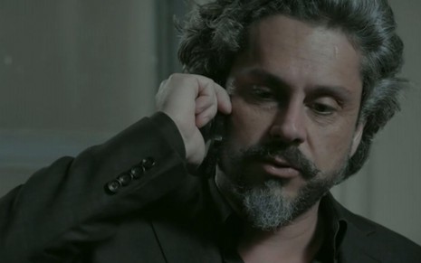 José Alfredo (Alexandre Nero) fala ao telefone; ele está em pé em seu escritório na Império