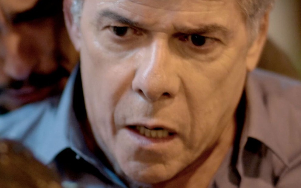 José Mayer em cena de Império: ator está em close, com camisa social cinza e tem expressão de surpresa no rosto