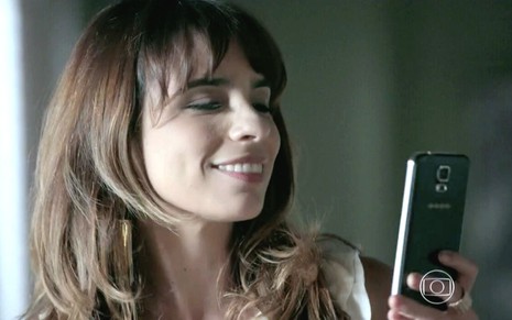 Maria Ribeiro em cena de Império: caracterizada como Danielle, atriz olha com satisfação para alguém fora do quadro