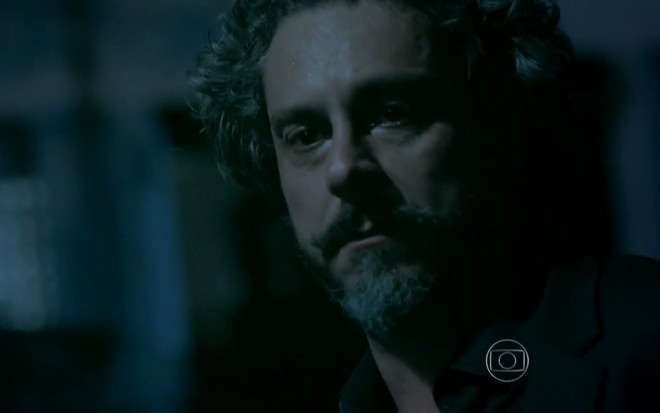 O ator Alexandre Nero olha para frente com cara de sério em cena da novela Império