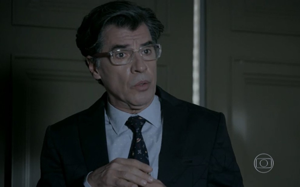 Paulo Betti grava com óculos de grau, terno e gravata e expressão de susto como Téo Pereira de Império