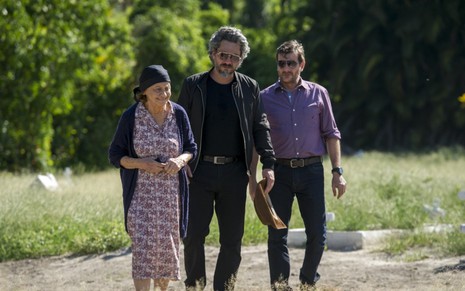 Laura Cardoso, Alexandre Nero e Roberto Birindelli caminham em campo em cena de Império