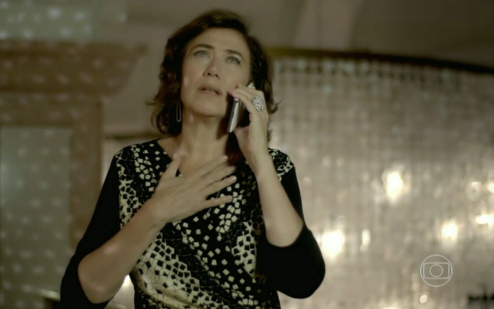 Lilia Cabral grava cena com expressão tensa ao telefone, como Maria Marta em Império, da Globo