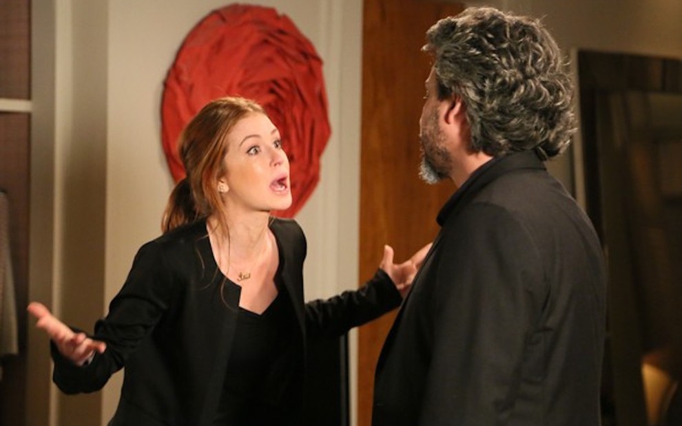 Com cabelo preso, Marina Ruy Barbosa grava cena de discussão, gesticulando com as mãos, diante de Alexandre Nero, como Maria Isis de Império