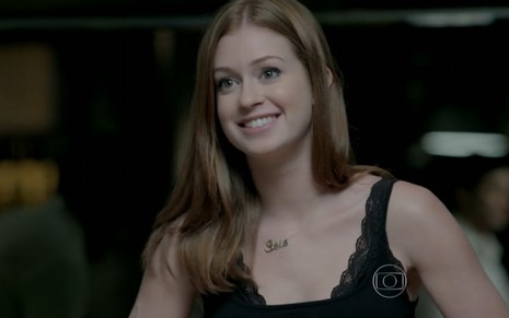 Marina Ruy Barbosa grava sorridente com vestido preto e cabelo ruivo solto como Maria Isis de Império