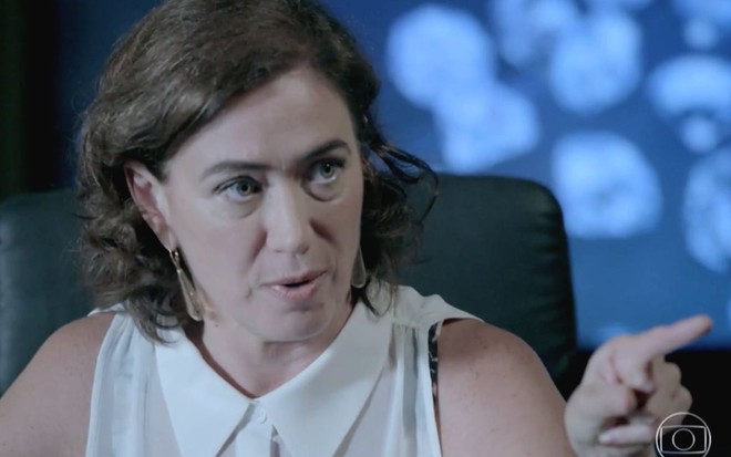 Lilia Cabral caracterizada como Maria Marta em Império, atriz olha para alguém com desconfiança e coloca dedo em riste