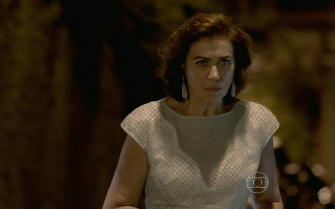 Lilia Cabral grava com vestido branco, cabelo curto, brincos e expressão de raiva como Maria Marta de Império