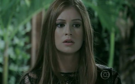 Maria Isis (Marina Ruy Barbosa) está em pé na recepção do restaurante de Vicente (Rafael Cardoso) em cena de Império