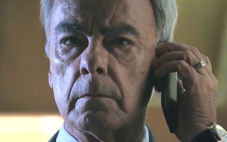 Em cena de Império, novela da Globo, Merival (Roberto Pirillo) atende telefone e faz cara de preocupado