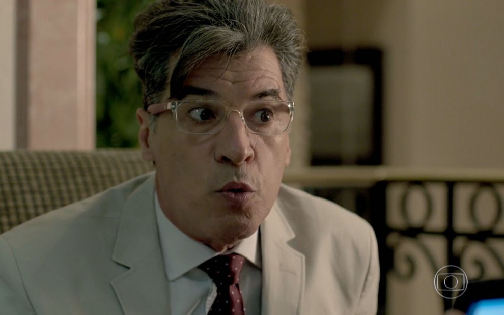 Téo Pereira (Paulo Betti) faz biquinho com terno claro e gravata de bolinha em cena de Império