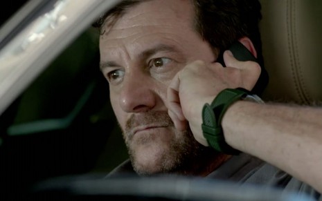 O personagem Josué (Roberto Birindelli) olha sério enquanto fala ao celular em cena da novela das nove Império, da Globo