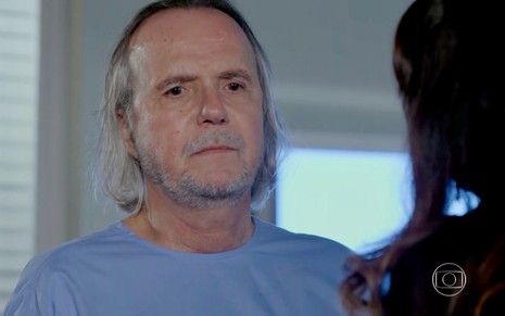O ator Tato Gabus Mendes grava cena de Império com avental de hospital e exibe um olhar triste e distante