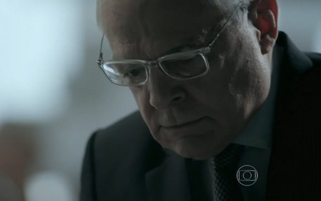 Othon Bastos grava com terno, óculos de grau, careca e expressão de raiva como Silviano de Império, reprise da Globo