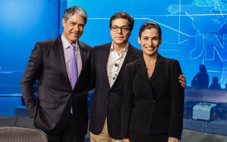 Ali Kamel posa entre William Bonner e Renata Vasconcellos no cenário do Jornal Nacional