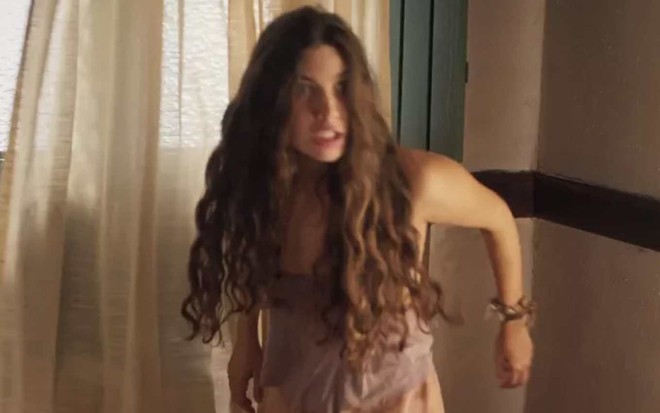 Atriz Alanis Guillen olha para frente com cara de fúria em cena de Pantanal