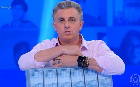 Luciano Huck segura mala com notas de R$ 100 em episódio do Quem Quer Ser Um Milionário?, da Globo