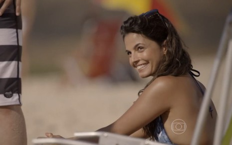 Emanuelle Araújo grava sorridente com biquíni em cena na praia como Dandara de Malhação Sonhos