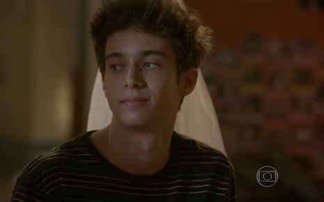 Guilherme Hamacek grava com camiseta listrada, sorriso tímido e olhar acolhedor como João de Malhação
