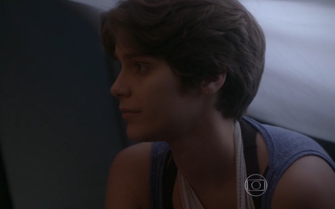 Isabella Santoni grava com faixa no braço, regata azul e expressão cabisbaixa como Karina de Malhação