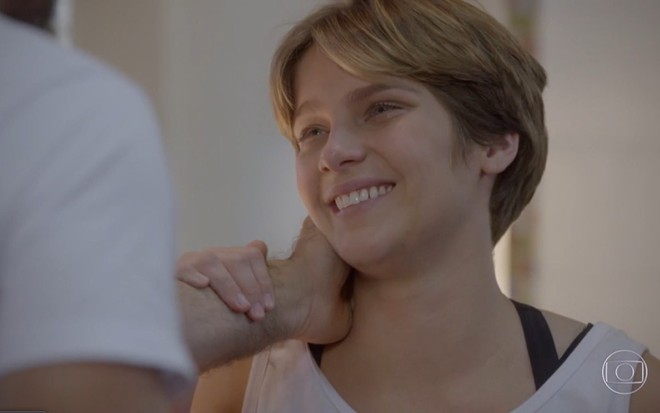 Isabella Santoni grava com regata branca e sorridente recebendo um carinho no rosto como Karina de Malhação