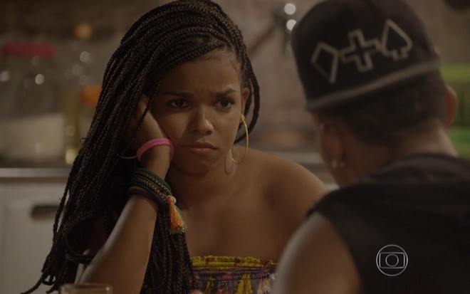 Jeniffer Nascimento grava com cabelo trançado, regata estampada e triste como Sol de Malhação Sonhos