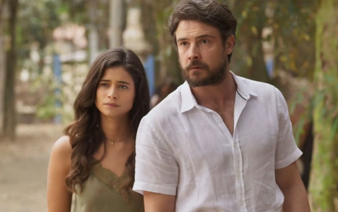 Isadora Cruz usa um regata verde; Sergio Guizé, uma camisa social branca. Ambos estão sérios em cena de Mar do Sertão.