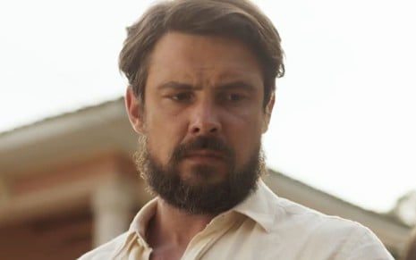 Sergio Guizé em cena de Mar do Sertão; ator usa uma camisa branca e tem o semblante fechado
