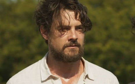 Sergio Guizé, caracterizado como José, tem a expressão séria e concentrada; ator veste camisa social branca