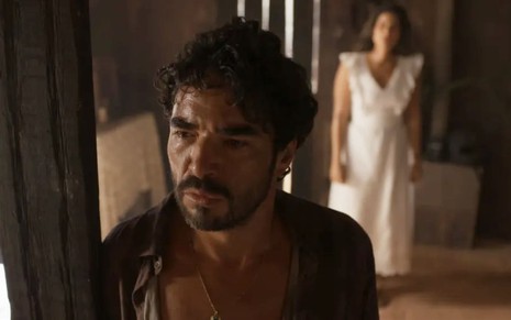Caio Blat caracterizado como Pajeú; ator tem o semblante abalado em cena de Mar do Sertão. Ao fundo, é possível ver Candoca (Isadora Cruz)