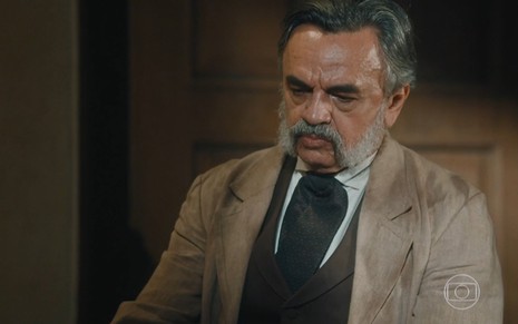 José Dumont grava com terno bege, barba grande e olhar sério como o coronel Eudoro de Nos Tempos do Imperador