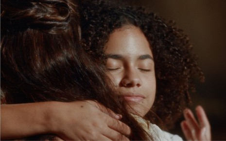 Zayla (Alana Cabral) abraça Pilar (Gabriela Medvedovski) no zungu, na Pequena África, em cena de Nos Tempos do Imperador
