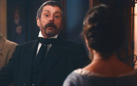 Tonico (Alexandre Nero) está em frente à Dolores (Daphne Bozaski) na sala da casa do casal em cena de Nos Tempos do Imperador