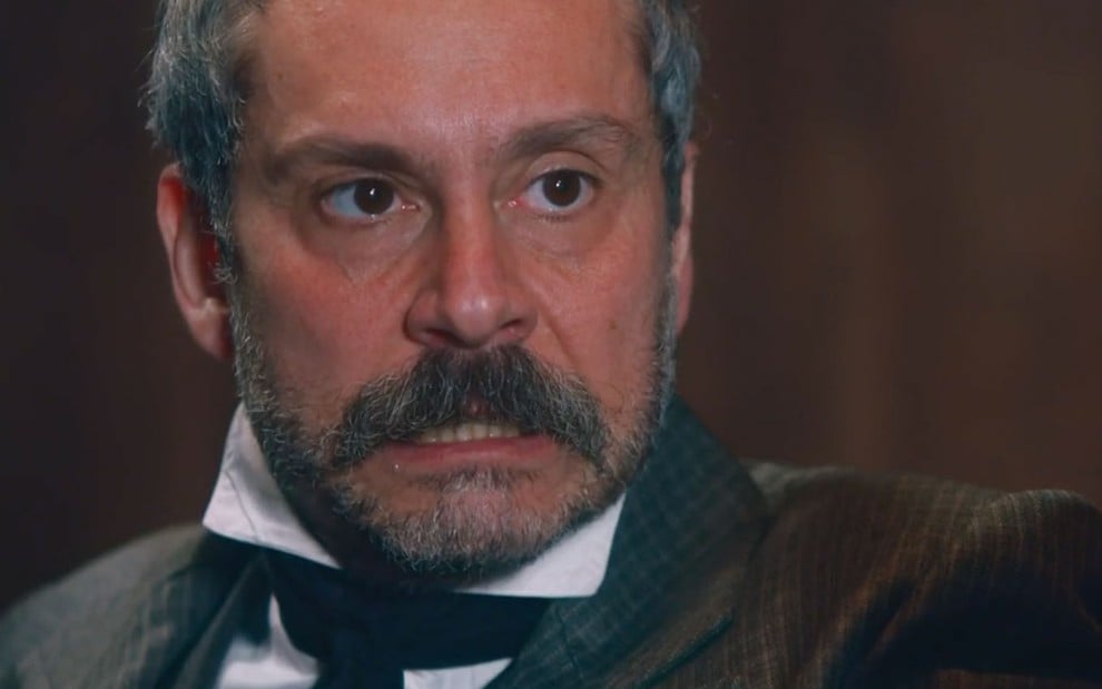 O ator Alexandre Nero, em um close up no rosto, com expressão de raiva como o Tonico em cena de Nos Tempos do Imperador