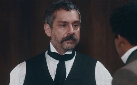 O ator Alexandre Nero com expressão de raiva e caracterizado como Tonico em cena de Nos Tempos do Imperador