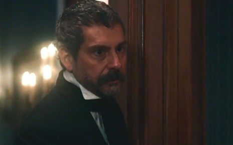 Tonico (Alexandre Nero) está em pé na porta do quarto de Dolores (Daphne Bozaski) em cena de Nos Tempos do Imperador