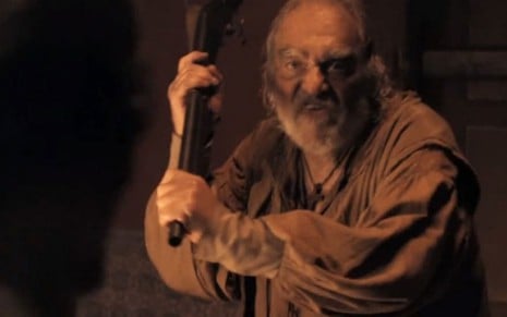 O ator Alexandre Zacchia segura uma espingarda como o Salustiano em cena de Nos Tempos do Imperador