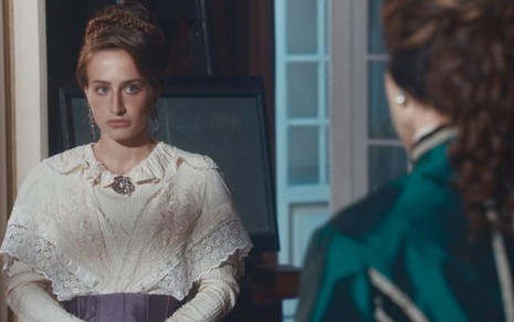 Leopoldina (Bruna Griphao) está em pé na sala do palácio da Quinta da Boa Vista e conversa com Luísa (Mariana Ximenes), que está de costas, em cena de Nos Tempos do Imperador