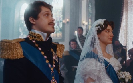Gastão (Daniel Torres) está vestido de farda e Isabel (Giulia Gayoso) de noiva em cena de Nos Tempos do Imperador
