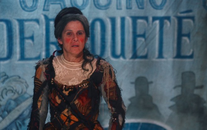 Ingrid Guimarães, caracterizada como Elvira, veste uma fantasia exagerada para seu espetáculo em cena de Nos Tempos do Imperador