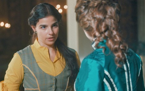 Pilar (Gabriela Medvedovski) está em pé e conversa com Luísa (Mariana Ximenes) na sala do palácio imperial na Quinta da Boa Vista em cena de Nos Tempos do Imperador