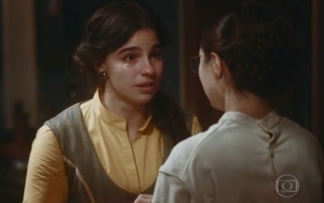 Pilar (Gabriela Medvedovski) chora ao conversar com Dolores (Daphne Bozaski) na sala da casa da irmã em cena de Nos Tempos do Imperador