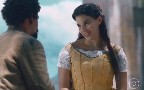 Gabriela Medvedovski grava com vestido amarelo e sorridente como Pilar em Nos Tempos do Imperador